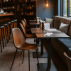 Super-Seat | Charlie Vintage Leren Kuipstoelen Cognackleurige leren kuipstoelen en donkere houten tafels bij een zachte, beklede bank. | Horecameubilair