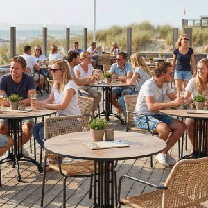 Super-Seat | Gietijzeren 4 tieners terras tafelonderstellen Parijs zwart Zwarte gietijzeren terrastafels, houten dek, gasten zitten en drinken, planten op tafels. | Horecameubilair