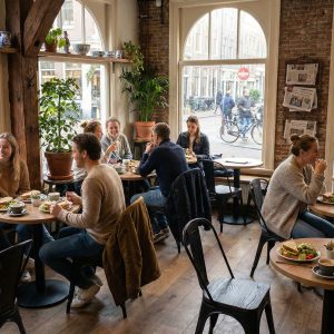 Super-Seat | Lix stoelen vintage mat Zwart hout | Zwarte houten Lix stoelen en tafels, zwart hout vloer, lichte café sfeer met grote ramen. | Horecameubilair