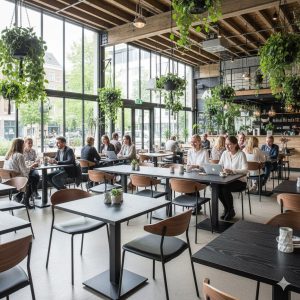 Super-Seat | Urban bistro melamine tafelbladen zwart 80x80cm Zwarte melamine tafels, houten stoelen en planten in een ruime, lichte caféruimte. | Horecameubilair