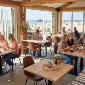 Super-Seat | Kasteel eiken melamine tafelbladen (120x67cm) | Lichtbruine eiken tafels, witte stoelen en barkrukken in zonnig strandrestaurant met zeezicht. | Horecameubilair