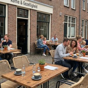 Super-Seat | Wermodin horeca tafels buiten 70x70cm en houten stoelen op een klinkerterras bij het café. | Horecameubilair