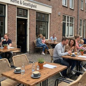 Super-Seat | Wermodin horeca tafels buiten 70x70cm en houten stoelen op een klinkerterras bij het café. | Horecameubilair