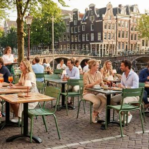 Super-Seat | Terrasstoelen horeca Wat je gaat tegenkomen zijn groene metalen stapelstoelen en houten tafels aan het water. | Horecameubilair