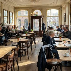 Super-Seat | Café Interieur Houten tafels, bruine gebogen Thon stoelen met spijlen, barkrukken en veel zonlicht in de ruimte. | Horecameubilair