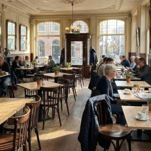 Super-Seat | Café Interieur Houten tafels, bruine gebogen Thon stoelen met spijlen, barkrukken en veel zonlicht in de ruimte. | Horecameubilair