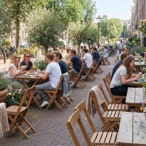 Super-Seat | Bruine houten tafels, vintage houten terrasstoelen op straat, zon en bloemen. | Horecameubilair