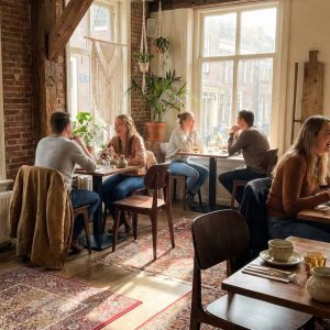 Super-Seat | Bonn Café Stoelen en Tafels Bruine Scandinavische stoelen en houten tafels, bakstenen muren, planten en warme tapijten. | Horecameubilair