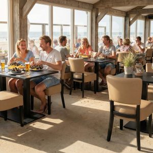 Super-Seat | Lisa Rome horeca stoelen Taupe | Zandkleurige stoffen stoelen rond houten tafels, zonlicht door ramen met uitzicht op het strand. | Horecameubilair