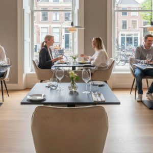 Super-Seat | Diamond fluwelen horeca stoelen champagne Fluwelen champagne stoelen en houten tafels in moderne, lichte restaurantsetting. | Horecameubilair