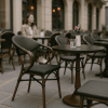 Super-Seat | Donker houten tafel met wit vaasje, glazen water, bruine textiel terrasstoel op stenen patio. | Horecameubilair