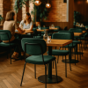 Super-Seat | Twee vrouwen praten aan houten tafel met benzine groene stapelstoelen, lege stoelen en tafels in café. | Horecameubilair