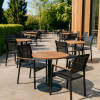 Super-Seat | Zwarte textileen stoelen, ronde houten tafels op stenen vloer bij glazen gevel, groen eromheen. | Horecameubilair