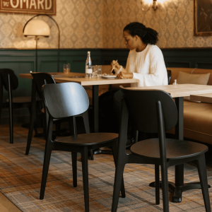 Super-Seat |Zwarte Scandinavische stoelen en houten tafels in een sfeervol café met groen behang. | Horecameubilair
