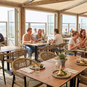 Super-Seat |Houten tafels en stoelen, bruine tinten, open ramen, uitzicht op zee en strand. | Horecameubilair