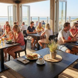 Super-Seat | Zwarte melamine tafels 120x67cm met metalen onderstel, uitzicht op zee, lichte strandstoelen. | Horecameubilair