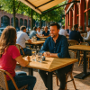 Super-Seat | Zwarte metalen stoelen en schorsrukken rond lichtbruin Werzalit tafels op terras. | Horecameubilair