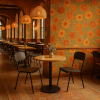 Super-Seat | Een restaurantinterieur met bloemenbehang, houten vloeren, zwarte stoelen, rieten hanglampen | Zwarte stoelen, ronde eikenhouten tafel met zwart onderstel, houten vloer, rotan lampen. | Horecameubilair