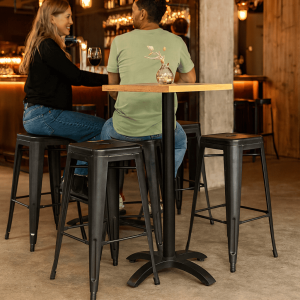Super-Seat | Zwarte metalen barkrukken, houten statafel, glazen vaas; sfeervol verlichte bistro. | Horecameubilair