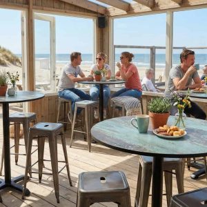 Super-Seat | Zwarte metalen statafels, houten stoelen buiten en binnen met zicht op strand en zee. | Horecameubilair