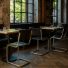 Super-Seat | Moderne Restaurantinrichting Houten tafels, zwarte buisframe stoelen, glaswerk, bestek, visgraatvloer en veel daglicht. | Horecameubilair