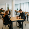 Super-Seat | Empire horeca tafels eiken melamine 80x80cm Licht eiken tafels, metalen onderstel, stoelen hout/metaal in moderne open ruimte. | Horecameubilair