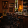 Super-Seat | Een gezellige bar met Jody horeca barkrukken Vier zwarte/bruine stapelbare barkrukken van metaal, houten bar, bruine muren, planten. | Horecameubilair