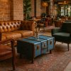 Super-Seat | Bruine leren bank, groene stoffen fauteuil, blauwe houten koffertafel, gemêleerd vloerkleed. | Horecameubilair