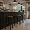 Super-Seat | Barkrukken metaal/hout zwart - Thon café | Zwarte metalen en houten barkrukken, zwarte bar, glazen schappen, veel daglicht. | Horecameubilair