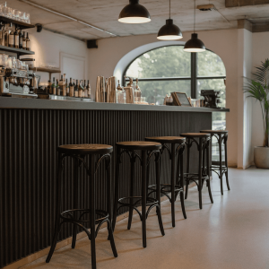 Super-Seat | Barkrukken metaal/hout zwart - Thon café | Zwarte metalen en houten barkrukken, zwarte bar, glazen schappen, veel daglicht. | Horecameubilair