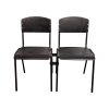 Super-Seat | Twee zwarte metalen stoelen met houten zitting/rug, verbonden door metalen koppeling, witte achtergrond. | Horecameubilair