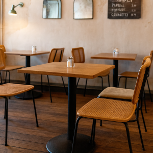 Super-Seat | Houten tafels, singel terrasstoelen, licht hout en rotan, pepermolens, spiegels aan lichte muur. | Horecameubilair