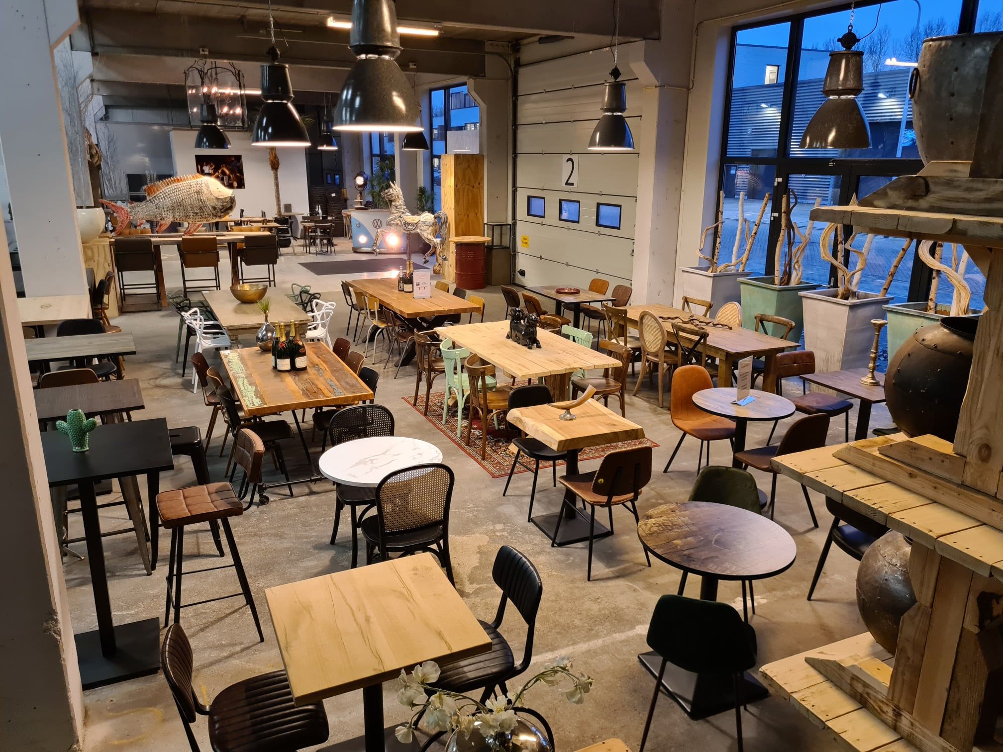 Super-Seat | Ruim Café Interieur | Mix van houten en metalen stoelen, tafels en barkrukken in natuurlijke tinten, grote ramen, industrieel design. | Horecameubilair
