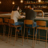 Super-Seat |Bruine Vanitas barkrukken met bronzen frame, groene tegels bar, lege stoelen, flessen op planken. | Horecameubilair
