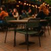 Super-Seat | Groene kunststof stoelen met armleuning en lege tafel op sfeervol verlicht terras. | Horecameubilair
