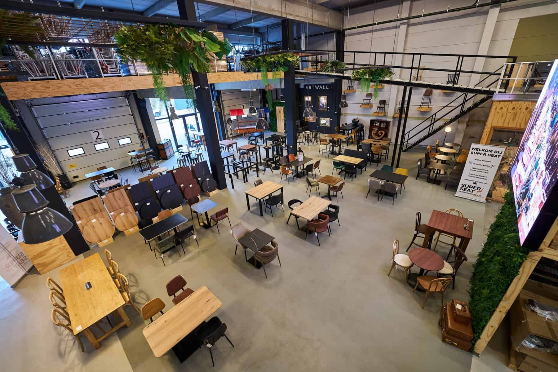 Super-Seat | Super Seat: Waarom kiezen voor houten horeca stoelen? | Houten tafels en stoelen met metalen frames, barkrukken; veel groen, grote ramen. | Horecameubilair