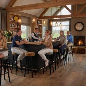 Super-Seat | Industriële barkrukken zwart oker geel velours | Zwart- en okergele velours barkrukken, houten tafels, grote ramen, houten balken, haard. | Horecameubilair