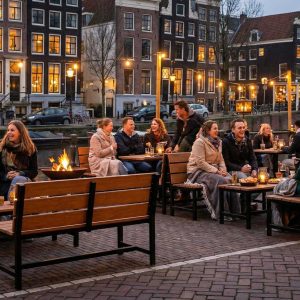 Super-Seat | Houten banken, metalen tafels; warme sfeer met lichtjes langs de gracht. | Horecameubilair