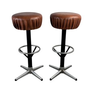 Super-Seat | Barkrukken van leer en staal | Bruine leren zittingen, zwarte kolommen, ronde voetensteunen, zilveren vierpoots metalen onderstel. | Horecameubilair