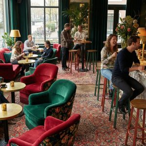 Super-Seat |Bloemenstoelen, ronde houten tafels, marmeren bar, leren barkrukken, grote ramen. | Horecameubilair